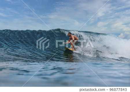 Shirtless male surfer on a wave at sunny day Shirtless male surfer on a wave at sunny day 96877843