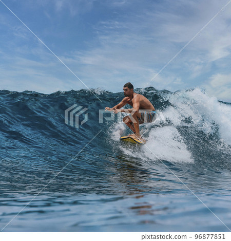 Shirtless male surfer on a wave at sunny day Shirtless male surfer on a wave at sunny day 96877851