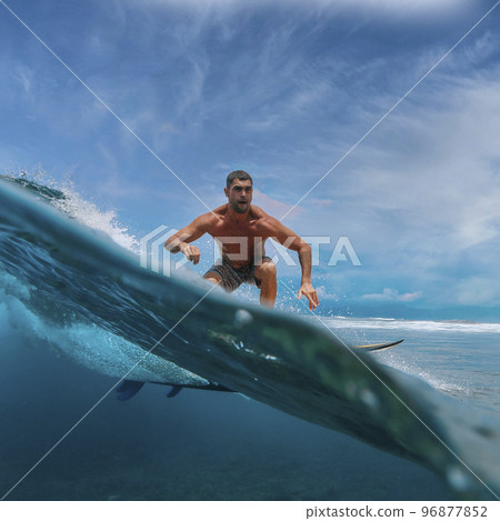 Shirtless male surfer on a wave at sunny day Shirtless male surfer on a wave at sunny day 96877852
