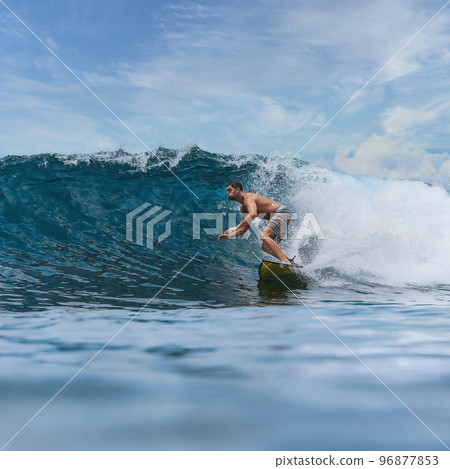 Shirtless male surfer on a wave at sunny day Shirtless male surfer on a wave at sunny day 96877853