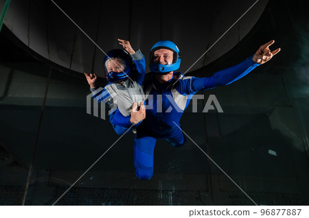 A man teaches a boy to fly in a wind tunnel. Lack of gravity. 96877887