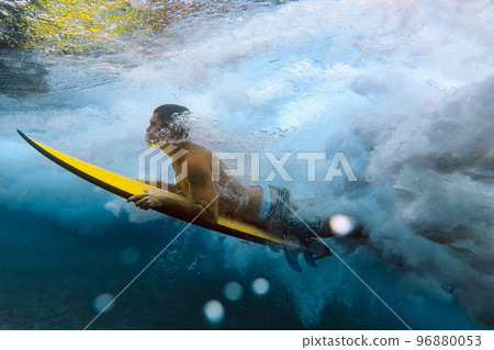 Shirtless male surfer diving in sea at Maldives 96880053