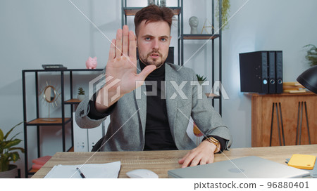 Businessman working on laptop showing stop gestuge, danger, rejection, warning, crisis, prohibition Businessman working on laptop showing stop gestuge, danger, rejection, warning, crisis, prohibition 96880401