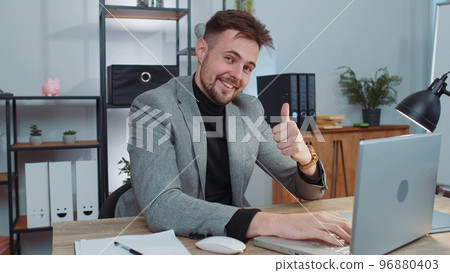 Happy business man looking approvingly at camera showing thumbs up, like positive sign, good news 96880403