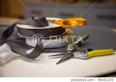 Close up of scissors and ribbon for flowers packing Close up of scissors and ribbon for flowers packing 96881229