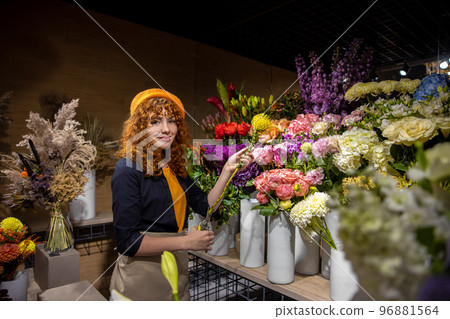 Pretty florist sorting the flowers and looking involved 96881564