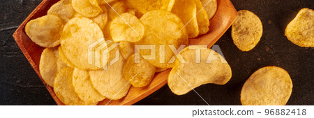 Potato chips or crisps panorama, a salty snack close-up, overhead flat lay 96882418