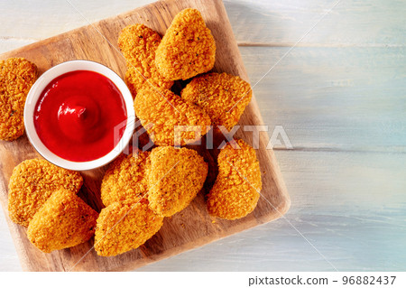 Chicken nuggets with ketchup sauce on a rustic wooden background 96882437