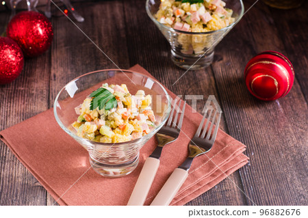 Olivier salad in bowls and Christmas decorations on a wooden table 96882676