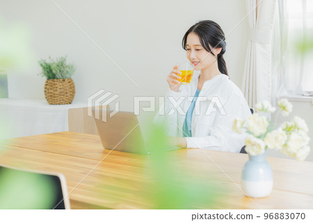 A woman looking at a computer in the living room A woman looking at a computer in the living room 96883070