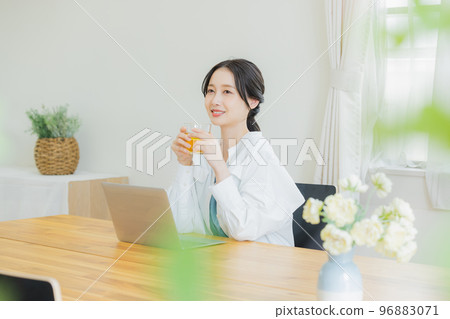 A woman looking at a computer in the living room 96883071