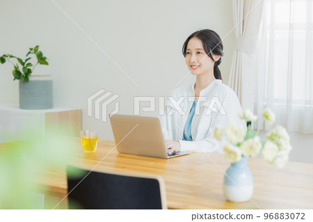A woman looking at a computer in the living room A woman looking at a computer in the living room 96883072