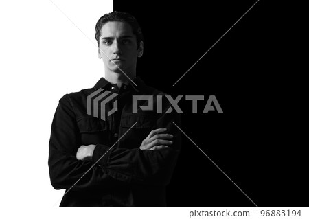 Black and white portrait of young man in casual shirt posing, seriously, attentively looking at camera. Businessman. Concept of men's fashion, business, emotions Black and white portrait of young man in casual shirt posing, seriously, attentively looking at camera. Businessman. Concept of men's fashion, business, emotions 96883194