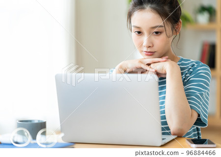 一個在看電腦時擔心的年輕女人 96884466