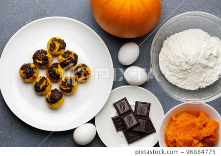 Cute little pumpkin muffins served at the table with ingredients Cute little pumpkin muffins served at the table with ingredients 96884775