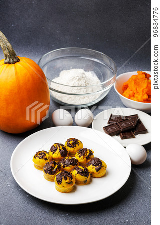 Cute little pumpkin muffins served at the table with ingredients Cute little pumpkin muffins served at the table with ingredients 96884776