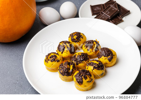 Cute little pumpkin muffins served at the table with ingredients Cute little pumpkin muffins served at the table with ingredients 96884777