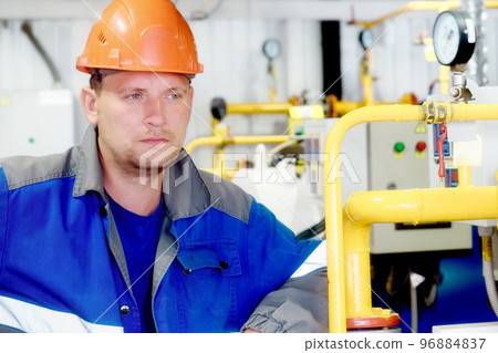 Portrait of engineer in construction helmet and work clothes on industrial background inside Portrait of engineer in construction helmet and work clothes on industrial background inside 96884837