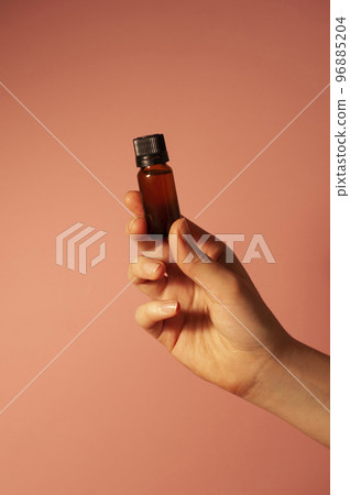 The girl is holding a brown bottle in hand. The girl is holding a brown bottle in hand. 96885204
