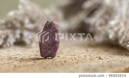 Rough Uncut Pinkish Ruby Stone on Wood Background Rough Uncut Pinkish Ruby Stone on Wood Background 96885654