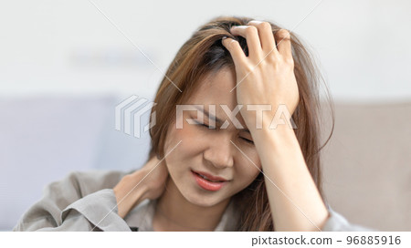 Stressed woman holding her temples with severe problems in her life, Family problems, Pressure from work, Poor financial, Despair in life, discouraged and deeply saddened, Panic attacks. 96885916