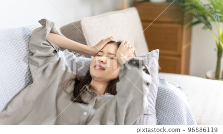 Stressed woman holding her temples with severe problems in her life, Family problems, Pressure from work, Poor financial, Despair in life, discouraged and deeply saddened, Panic attacks. Stressed woman holding her temples with severe problems in her life, Family problems, Pressure from work, Poor financial, Despair in life, discouraged and deeply saddened, Panic attacks. 96886119