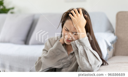 Stressed woman holding her temples with severe problems in her life, Family problems, Pressure from work, Poor financial, Despair in life, discouraged and deeply saddened, Panic attacks. Stressed woman holding her temples with severe problems in her life, Family problems, Pressure from work, Poor financial, Despair in life, discouraged and deeply saddened, Panic attacks. 96886689
