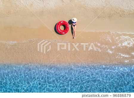 Aerial view of a lying woman in hat with red swim ring 96886879