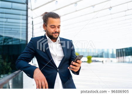 Businessman standing outdoor use smartphone Businessman standing outdoor use smartphone 96886905
