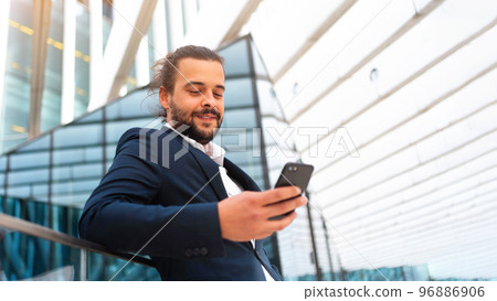 Businessman standing outdoor use smartphone Businessman standing outdoor use smartphone 96886906