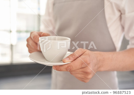 Your coffee, please. Cropped image of a man holding a cup of good coffee against the background of a window. With space to copy. High quality photo Your coffee, please. Cropped image of a man holding a cup of good coffee against the background of a window. With space to copy. High quality photo 96887523