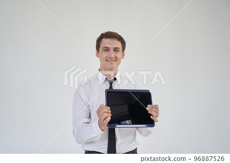 I work with joy. A handsome young man using his laptop and showing it to the camera on a gray background with space to copy. High quality photo I work with joy. A handsome young man using his laptop and showing it to the camera on a gray background with space to copy. High quality photo 96887526