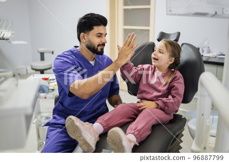 Little girl and excited confident man dentist giving high five. 96887799