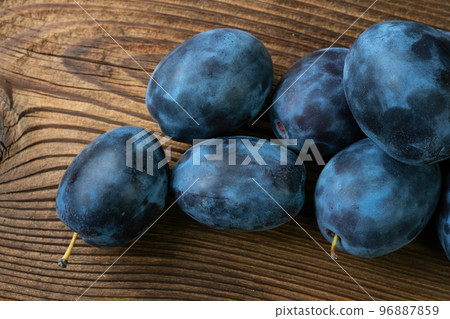 Ripe plums on a wooden table 96887859