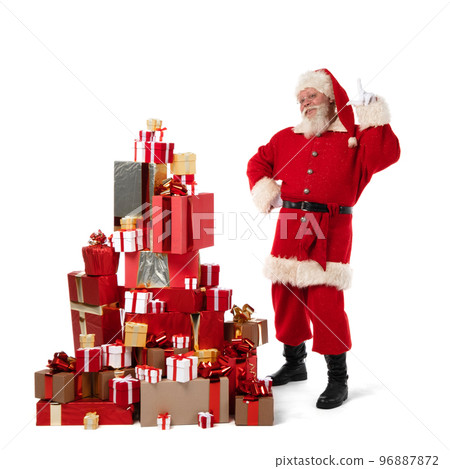 Santa Claus with pile of Christmas gifts 96887872