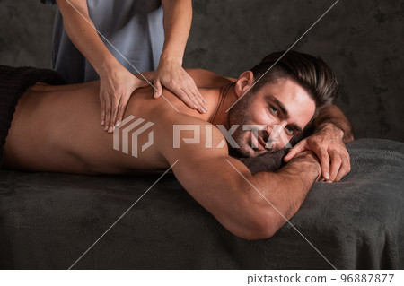 Masseur doing back massage on man 96887877