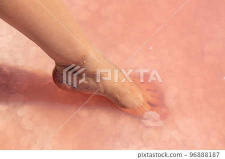 Woman foot in salt flakes in pink water, spa Woman foot in salt flakes in pink water, spa 96888187