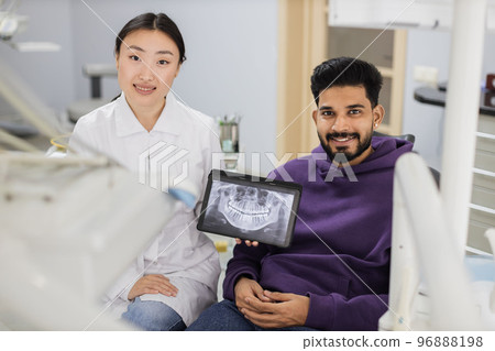 Young asian woman dentist holding tablet pc with x ray scan. Young asian woman dentist holding tablet pc with x ray scan. 96888198