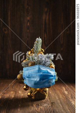 Christmas tree with surgical or medical mask on wooden background 96888975