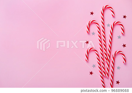 Christmas composition. Candy canes, holiday decorations on a pink background. Christmas composition. Candy canes, holiday decorations on a pink background. 96889088