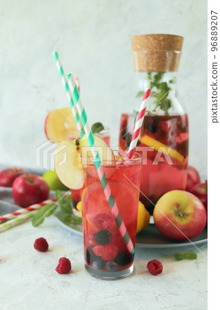 Detox drink from apples, berries, mint and citrus in glasses and in a decanter, on the table, seasonal drinks from organic natural ingredients 96889207