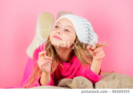 Winter season concept. Winter fashion accessory. Winter accessory concept. Girl long hair dream pink background. Kid girl knitted hat. Kid dreamy lean on pillows. Winter season coziness attribute Winter season concept. Winter fashion accessory. Winter accessory concept. Girl long hair dream pink background. Kid girl knitted hat. Kid dreamy lean on pillows. Winter season coziness attribute 96889305