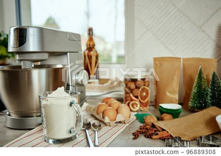Preparation of dough in an electric mixer at home. Professional mixer for kneading dough and food ingredients in kitchen interior. Modern appliances in the kitchen Preparation of dough in an electric mixer at home. Professional mixer for kneading dough and food ingredients in kitchen interior. Modern appliances in the kitchen 96889308