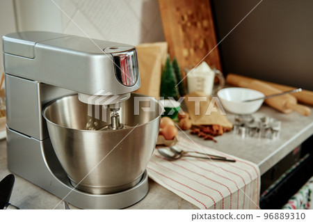 Preparation of dough in an electric mixer at home. Professional mixer for kneading dough and food ingredients in kitchen interior. Modern appliances in the kitchen Preparation of dough in an electric mixer at home. Professional mixer for kneading dough and food ingredients in kitchen interior. Modern appliances in the kitchen 96889310