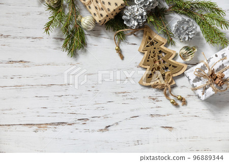 Christmas gold decor, fir tree twigs and gifts box on a white wood background. View from above. Copy space. 96889344