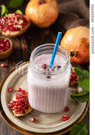 Vegan protein smoothie made from pomegranate and banana on a rustic wooden table. Healthy food, healthy lifestyle. Foodism, raw food diet. Vegan protein smoothie made from pomegranate and banana on a rustic wooden table. Healthy food, healthy lifestyle. Foodism, raw food diet. 96889409