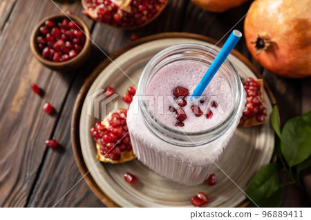 Vegan protein smoothie made from pomegranate and banana on a rustic wooden table. Healthy food, healthy lifestyle. Foodism, raw food diet. Vegan protein smoothie made from pomegranate and banana on a rustic wooden table. Healthy food, healthy lifestyle. Foodism, raw food diet. 96889411