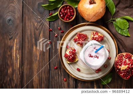 Vegan protein smoothie made from pomegranate and banana on a rustic wooden table. Healthy food, healthy lifestyle. Foodism, raw food diet. Top view flat lay. Copy space. Vegan protein smoothie made from pomegranate and banana on a rustic wooden table. Healthy food, healthy lifestyle. Foodism, raw food diet. Top view flat lay. Copy space. 96889412