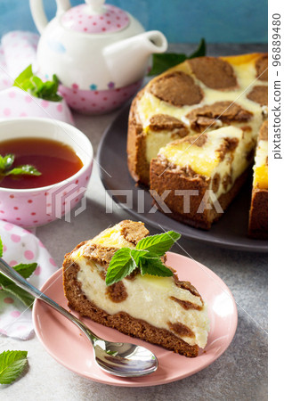 The concept of breakfast or relaxation. Chocolate New York cheesecake and mint tea cup on concrete background. The concept of breakfast or relaxation. Chocolate New York cheesecake and mint tea cup on concrete background. 96889480
