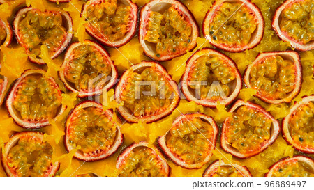 Fresh sliced passion fruits falling into juice, top view Fresh sliced passion fruits falling into juice, top view 96889497